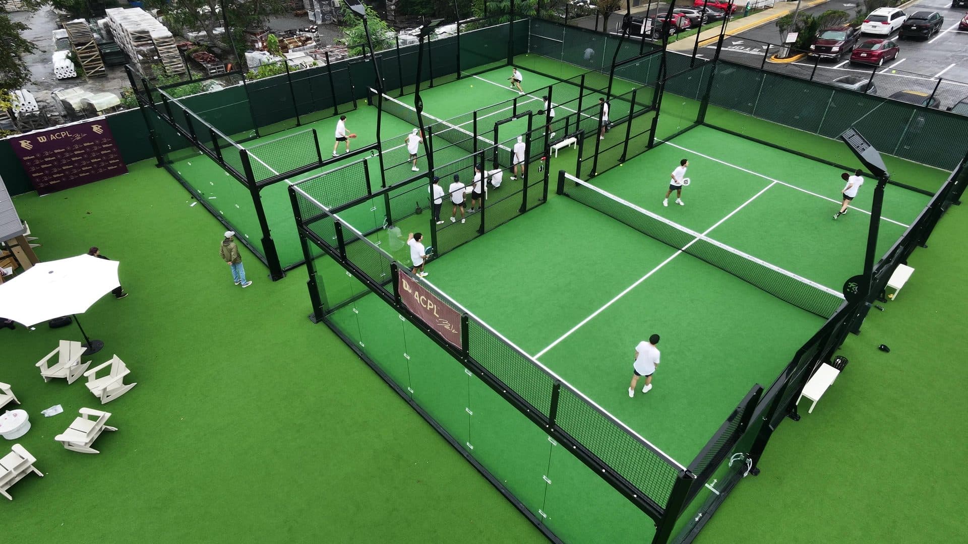 Aerial view of three courts in play at the DC City Invitational, with the Wilson ACPL by Bela backdrop and court banner